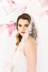 veils: woman in wedding dress wearing a veil with lace on the edge