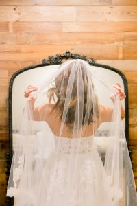 woman wearing veil looking in a mirror