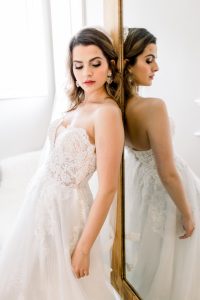 woman in wedding dress leaning against a mirror at get fabulous event