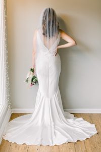 woman standing in wedding dress with a short veil