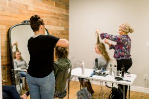 women getting hair curled at get fabulous event