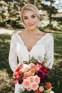 real bride holding flowers in lace long sleeve gown