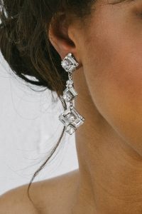 woman wearing drop crystal earrings
