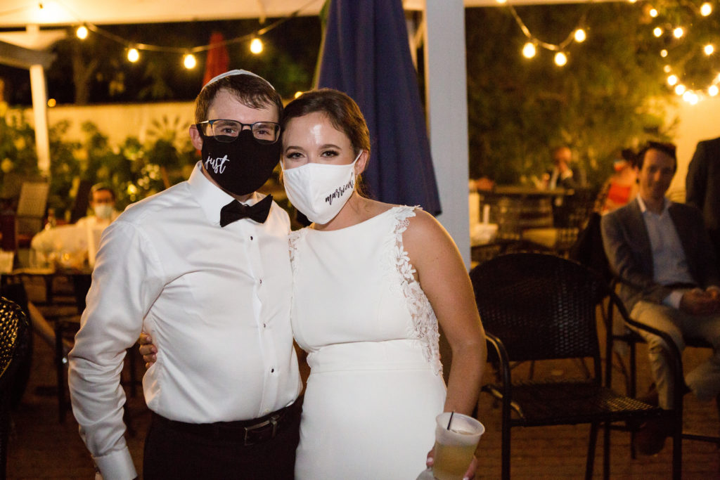 bride and groom wearing "just married" masks